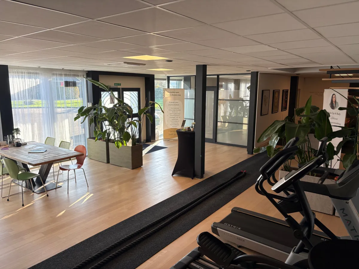 De lichte ontvangstruimte van het centrum met de grote tafel en de ingang